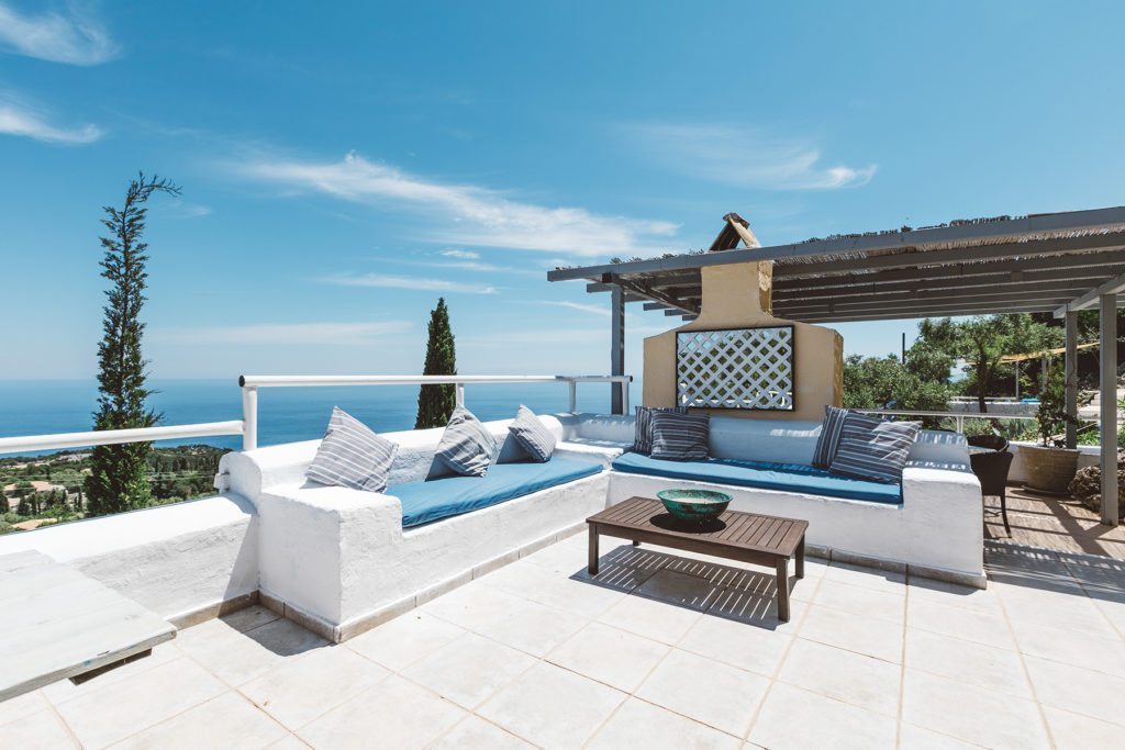 Traditional Greek island style stone seating with blue cushions at Villa Tal Hamsa