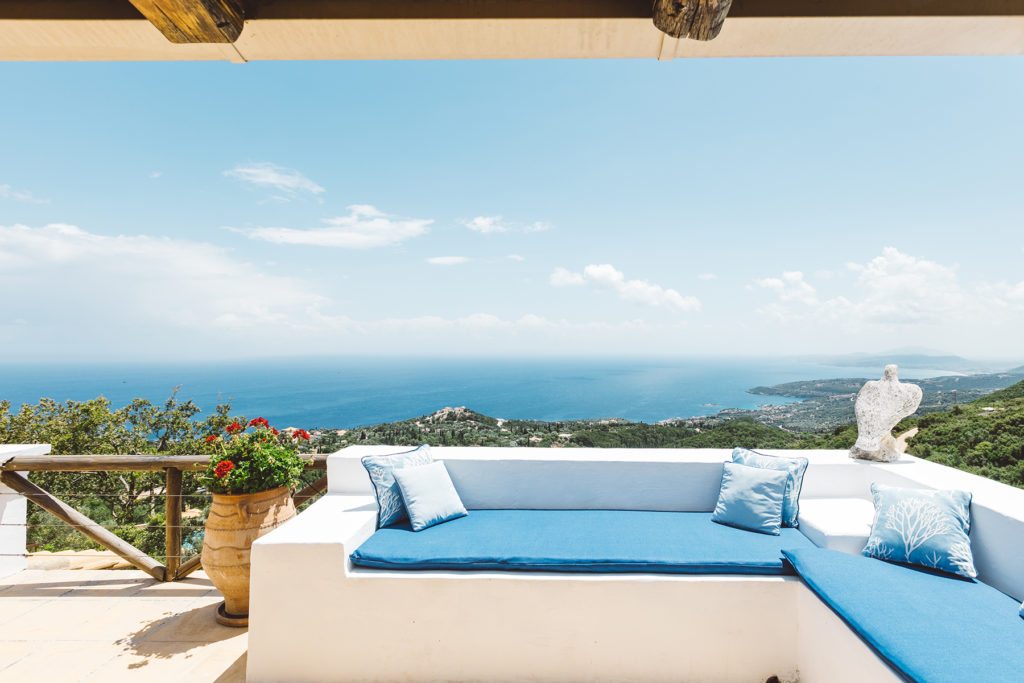 white clay greek styled sofa with a beautiful view of the sea