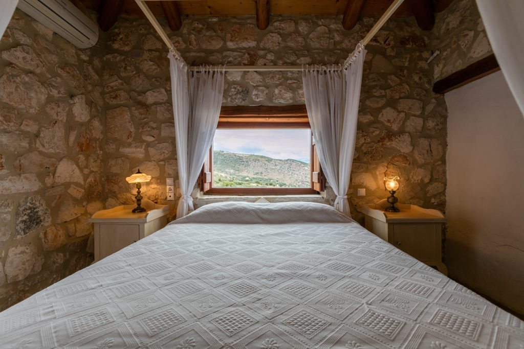 View of the Zakynthos hilltops from a beautiful wooden four poster bed