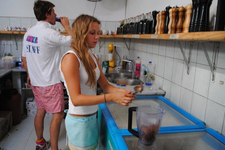 Girl with blue apron working in a kitchen