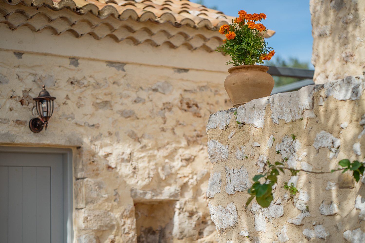 Traditional stone greek villa for 6 people in Zakynthos with blue wooden shutters and plants in terracotta pots