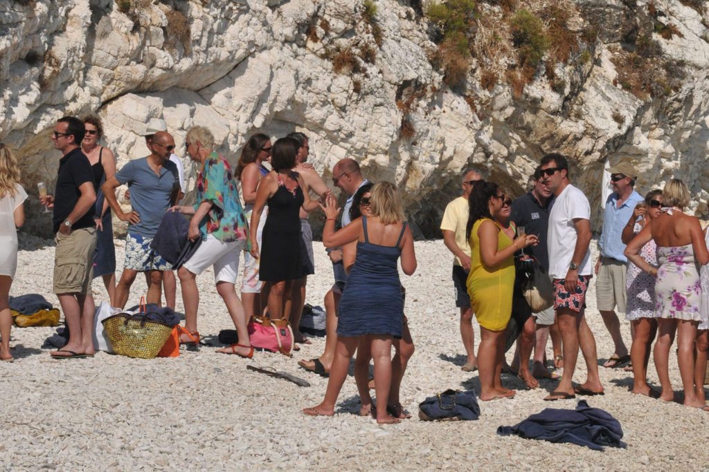 A group of people enjoying a champagne breakfast on a beach on the island of Zakynthos for a corporate event in Greece