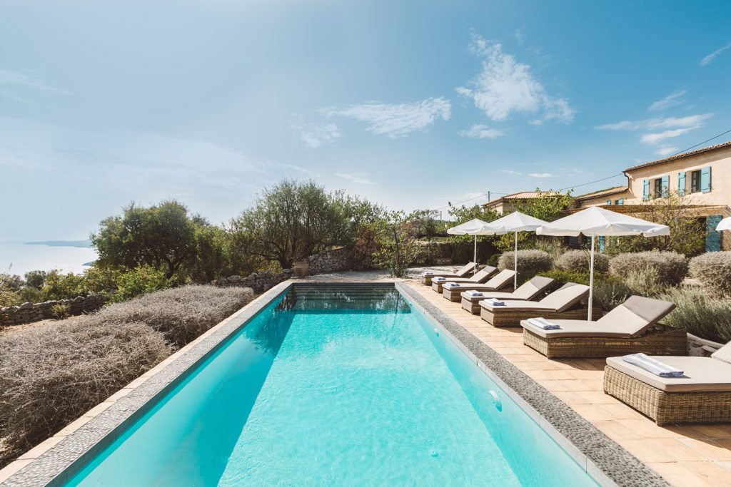 The dazzling blue pool and chic sun beds at villa Halcyon