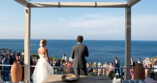A bride groom stand on the terrace of luxury villa Figari with sea view, a perfect Location by the sea for a wedding in Greece