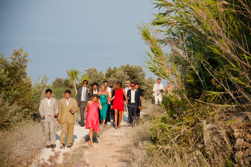 Wedding guests walk through the wild landscape of north zakynthos towards The Peligoni Club